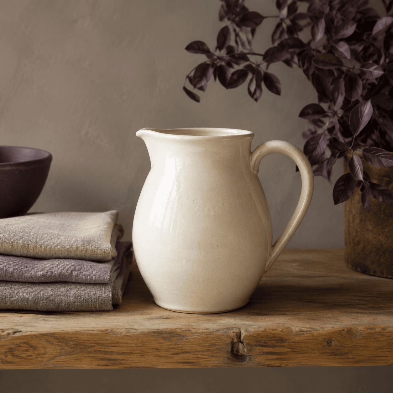 Cream crackle-glaze jug that doubles as a sculptural shelf object.
