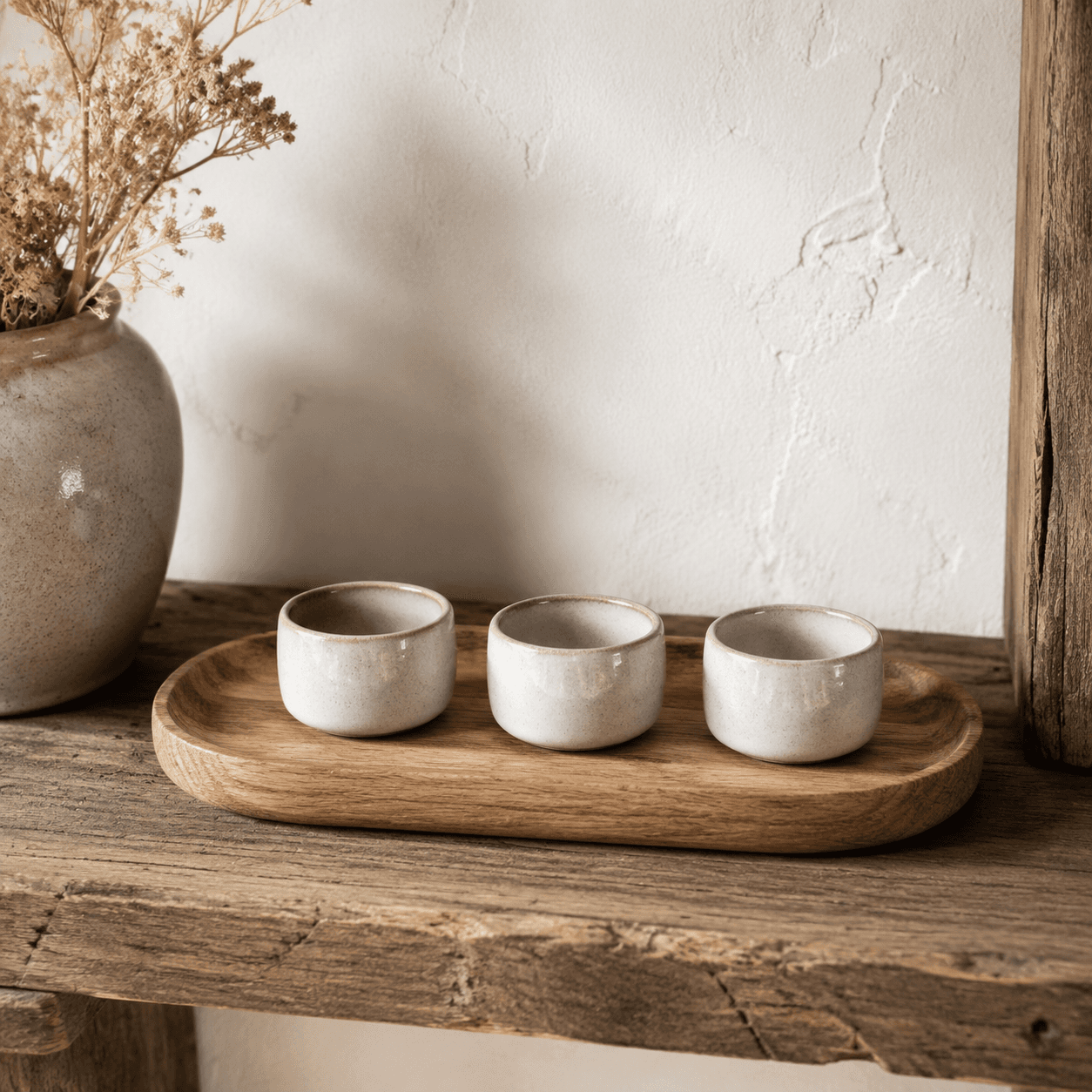 Set of three matte ceramic tealight cups in chalk, fig and pine tones.